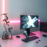 turned-on black flat screen monitor beside keyboard